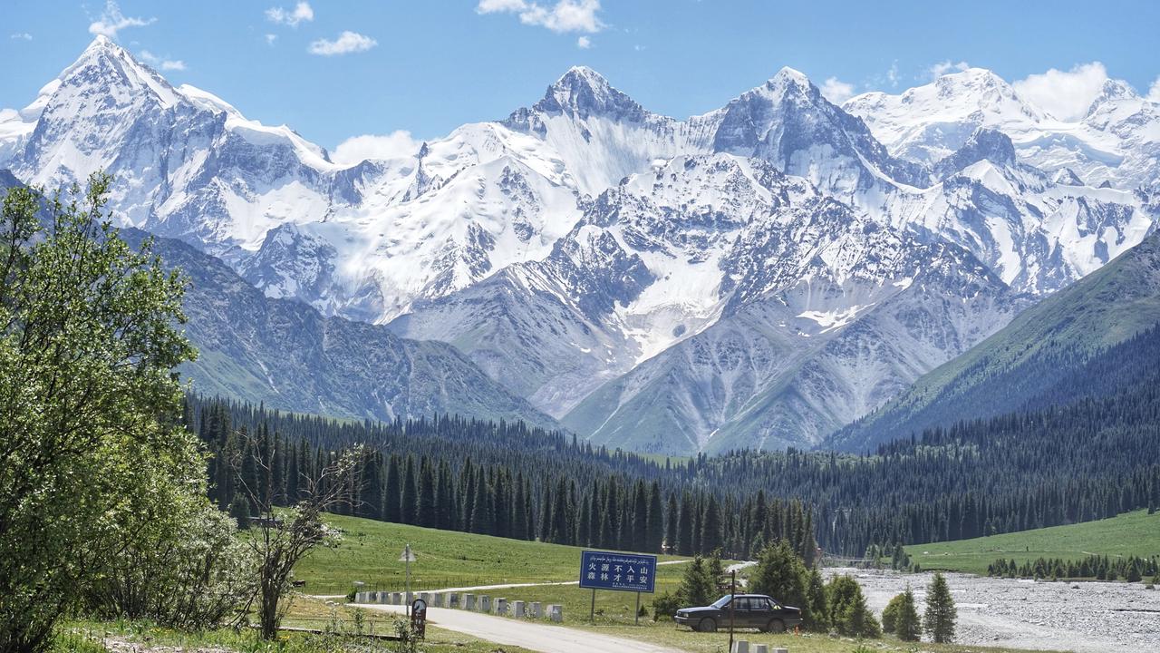 Snow-covered mountains and an alpine valley in Xinjiang, China